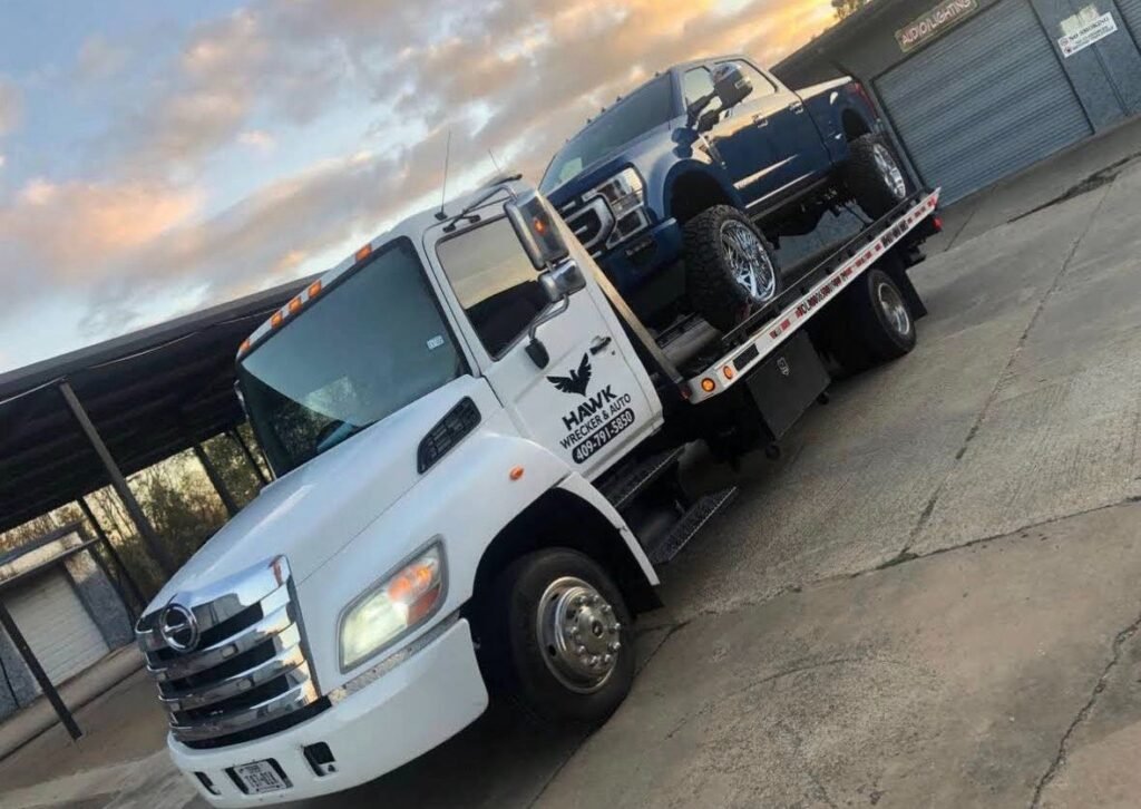 A Hawk Towing flatbed truck providing professional 24/7 accident recovery and towing service in Beaumont, TX.